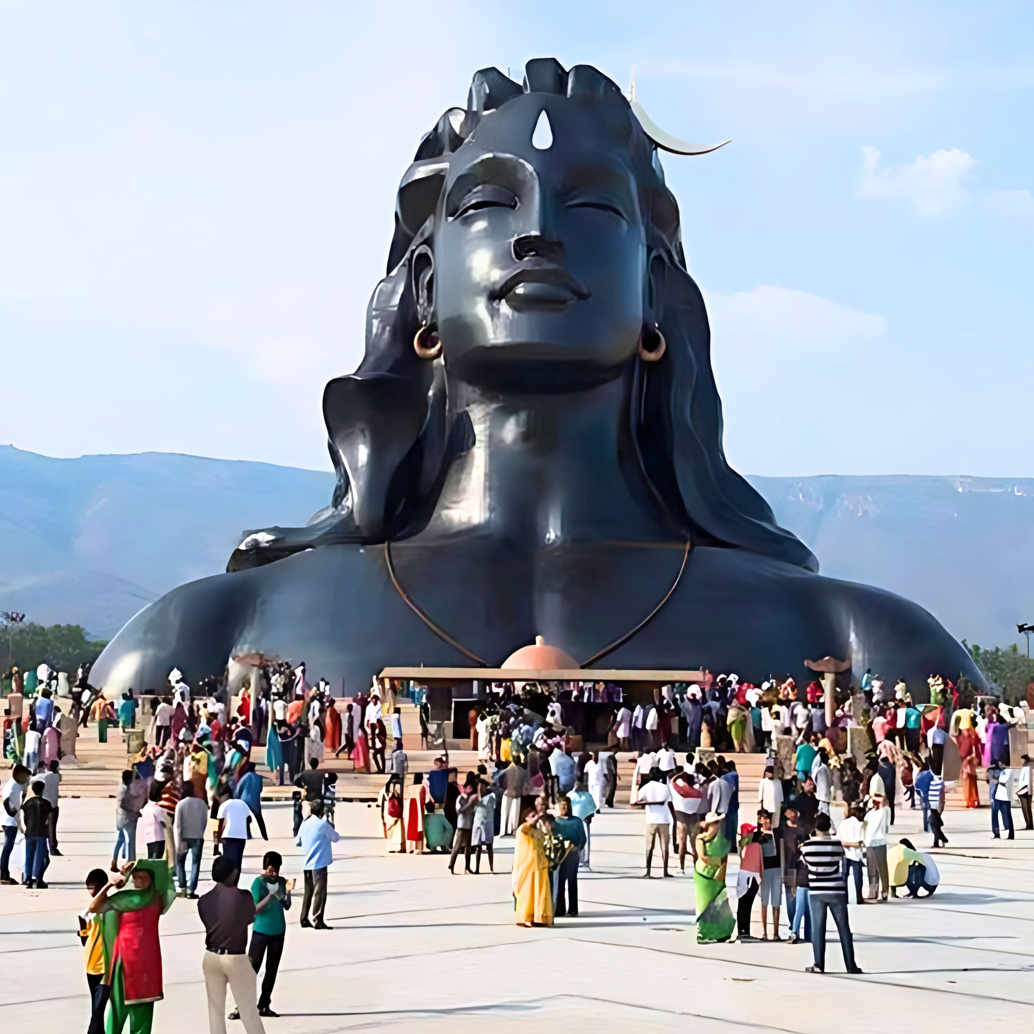 Adiyogi Shiva statue at Isha Yoga Center in Coimbatore with visitors and scenic Velliangiri Hills.